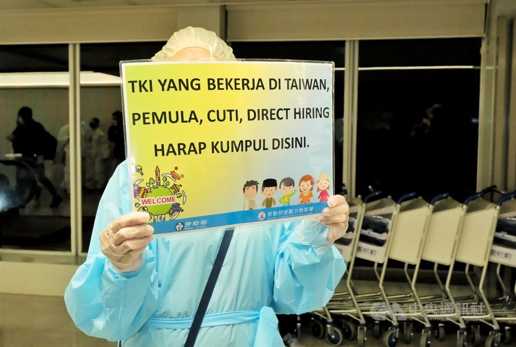 Một quan chức của Cơ quan Phát triển Lực Lượng Lao động cầm một bảng bằng tiếng Indonesia để chào mừng những người lao động mới đến (CNA) 